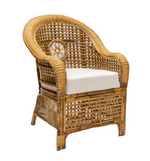 The Julianna Occasional Chair by Varnish Collection features a curved backrest and arms, white seat cushion, and woven rattan design—a handmade, elegant piece crafted from natural materials.
