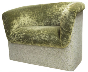 Green velvet upholstered armchair with a curved back and padded seat, inspired by the elegance of the Deco Rolled Arm Chair by LEE PARKER, sitting gracefully on a patterned fabric base.