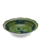 The Oriente Italiano Malachite Dinnerware & Decor Collection by Ginori 1735 features scalloped ceramic bowls with a green interior and blue floral patterns, inspired by exotic florals and Italian porcelain craftsmanship.