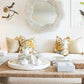 Modern living room with a white Denby Sofa by Hickory Chair adorned with floral cushions featuring Spring-Down seat cushions, a large circular mirror above, bird-themed wall art, and a coffee table displaying decor items, books, and a woven tray.
