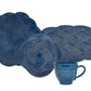 Four blue woven placemats from Juliska’s Le Panier Mystic Knot Denim Dinnerware and Serveware Collection, featuring intricate mystic knot designs, are displayed behind a matching blue Juliska mug adorned with a similar knot motif, evoking the artful elegance of a large charger or serving platter.