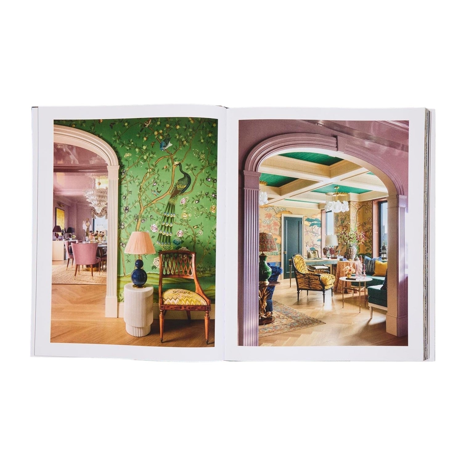 The open "Design Reimagined" book by Rizzoli showcases colorful, ornately decorated rooms with patterned wallpaper and elegant furniture—perfect inspiration for glamorous home decor.