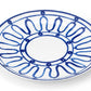 Round white plate from Themis Z's Kyma Blue Dinnerware Collection, featuring a blue abstract looped pattern around the rim and inner section, inspired by the Aegean Sea, with a plain center.
