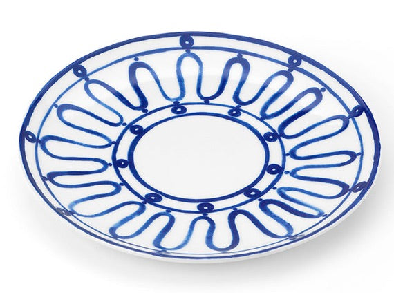 Round white plate from Themis Z's Kyma Blue Dinnerware Collection, featuring a blue abstract looped pattern around the rim and inner section, inspired by the Aegean Sea, with a plain center.