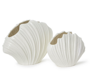 The White Shell Vase Collection by Two's Company features two textured white porcelain vases, one large and one small, shaped like seashells with open tops—perfect for adding seaside charm to any setting.