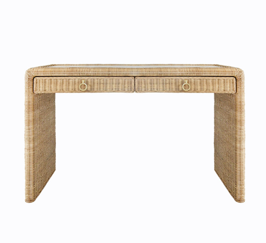 The Adrien Desk by Worlds Away is a rectangular woven rattan desk with two front drawers and brass ring handles, offering a natural texture and minimalist design—ideal for an elegant workspace.