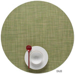 A white cup and saucer with a red spoon sit atop a green Chilewich Round Placemat, labeled "Dill" in the lower right corner and crafted from Terrastrand yarns.