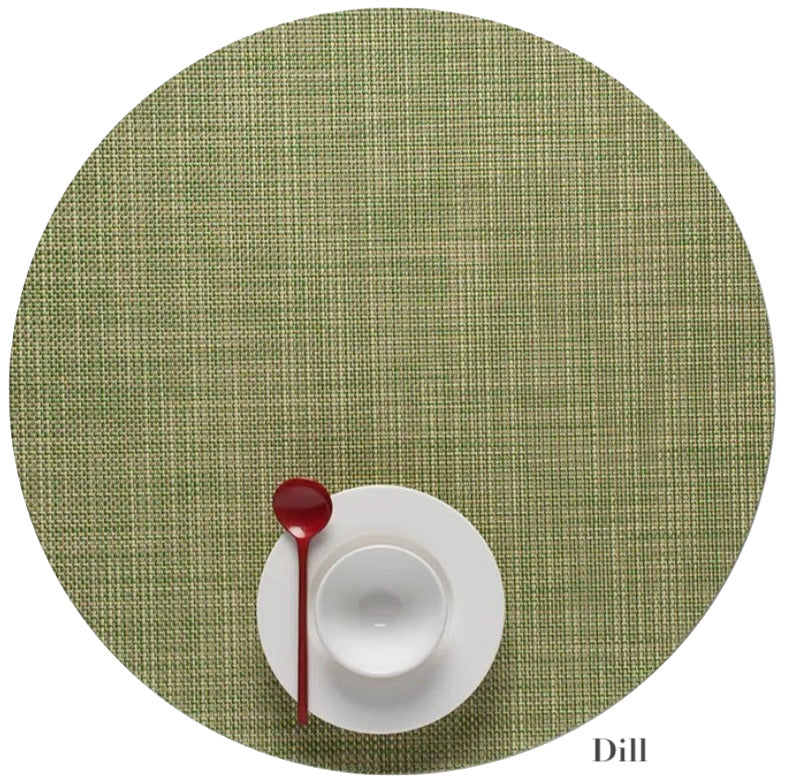 A white cup and saucer with a red spoon sit atop a green Chilewich Round Placemat, labeled "Dill" in the lower right corner and crafted from Terrastrand yarns.