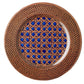 The Patagonia Blue Melamine Dinnerware Collection by Mario Luca Giusti features a round plate with a woven brown rim and blue geometric lattice center, uniting antique charm and modern style.