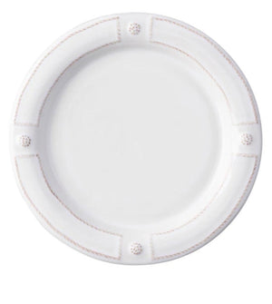 A round white ceramic plate from Juliska’s Berry & Thread French Panel Dinnerware Collection, featuring a raised rim inspired by Parisian architecture with four textured accents evenly spaced around the edge.