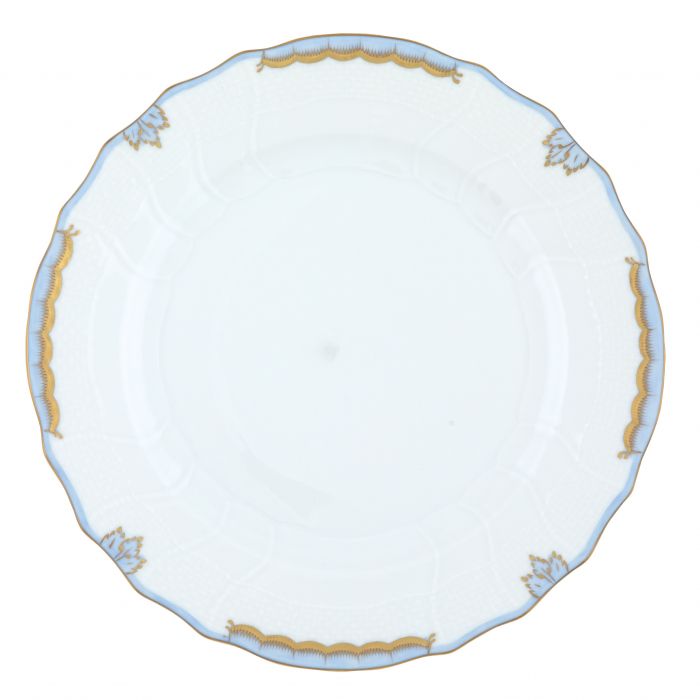 Herend’s Princess Victoria Light Blue Collection features a white porcelain plate with scalloped edges, gold trim, and delicate blue accents, echoing timeless elegance fit for royalty.