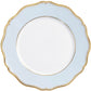 A round, white plate from Raynaud’s Mazurka Or Fond Bleu Gris Dinnerware Collection, featuring a light blue border, gold trim, and a scalloped edge design.