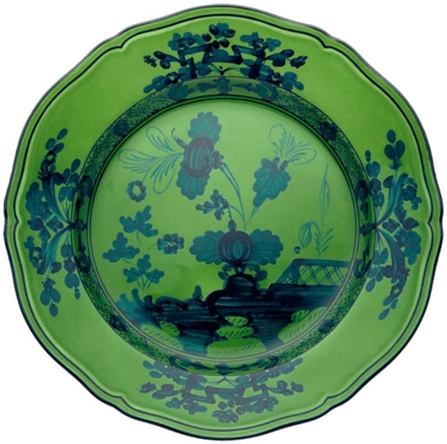 A decorative green plate with blue floral patterns and scalloped edges, viewed from above, from the Oriente Italiano Malachite Dinnerware Collection by Ginori 1735.
