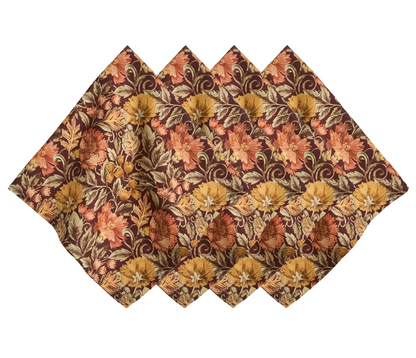 Five Willa Amber Napkins by Juliska, featuring a brown, orange, and gold floral motif with scalloped edges, are arranged in a fan shape to showcase their intricate autumn-themed design.