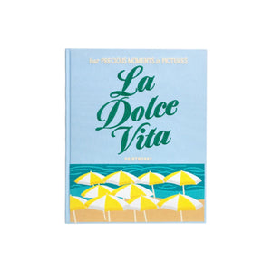The PrintWorks La Dolce Vita Photo Album features a cover with yellow and white beach umbrellas by the sea, and the subtitle "Your Precious Moments in Pictures"—a perfect coffee table keepsake for storing your favorite memories.