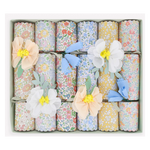 A box of twelve Meri Meri Flower Crackers, each decorated with pastel paper flowers, makes delightful party favors and comes neatly arranged in rows.