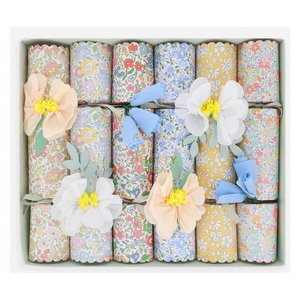 A box of twelve Meri Meri Flower Crackers, each decorated with pastel paper flowers, makes delightful party favors and comes neatly arranged in rows.