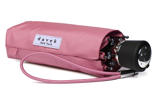 A folded pink Mini Pink Umbrella by Davek with a matching fabric case and wrist strap, perfect for the luxury lifestyle, is a must-have accessory.