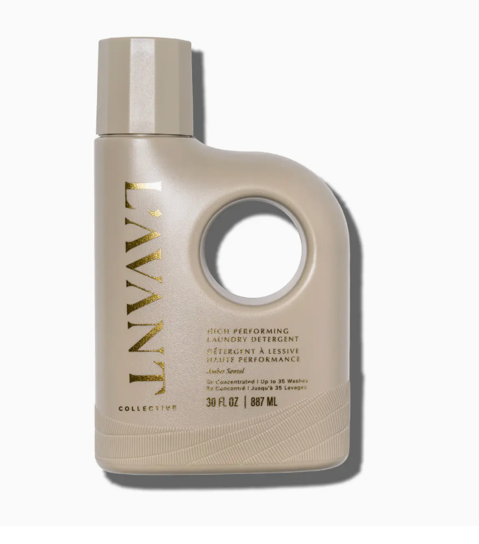 Beige bottle of L’Avant Collective Ambre Santal Collection laundry detergent with a circular handle cutout, gold text, and a sandalwood fragrance.