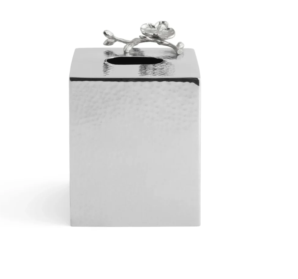 A square, silver tissue box cover from the Michael Aram White Orchid Bath Collection features a hammered texture and a decorative metal flower accent on top near the opening, making it a perfect complement to other orchid bathroom accessories or the matching White Orchid Soap Dispenser for an elegant, coordinated look.