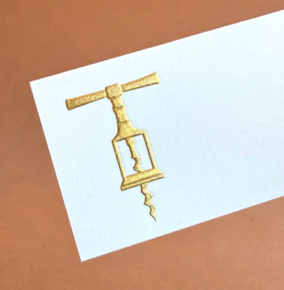 The Printery Gold Corkscrew Place Card Set features white tented cards with a gold corkscrew illustration on a brown background.