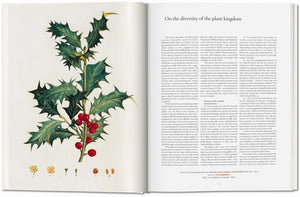 An open book, A Garden Eden by Taschen, displays a botanical illustration of a holly branch with leaves and red berries on the left, and an article titled "On the diversity of the plant kingdom" on the right—a true TASCHEN classic.