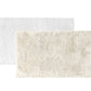 Two Egoist Cloud Bath Rugs by Graccioza, one white and one beige, made from soft Egyptian cotton, are arranged overlapping on a plain white background.