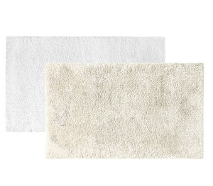 Two Egoist Cloud Bath Rugs by Graccioza, one white and one beige, made from soft Egyptian cotton, are arranged overlapping on a plain white background.