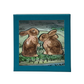 The Juliska Clever Creatures Bunny Salt and Pepper Set features two hand-painted ceramic bunnies with pink bows, presented in a gift box with blue edging and a green illustrated background.