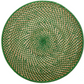 The Calypso Rattan Placemat Set by Deborah Rhodes features hand-woven, round natural rattan mats with a green and beige spiral pattern, adding elegant versatility to indoor or outdoor settings.