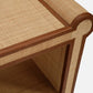 Close-up of the Large Matthew Console by Made Goods, highlighting its woven rattan and wood finish with full-grain leather trim on the corners, showcasing the console's distinctive design.
