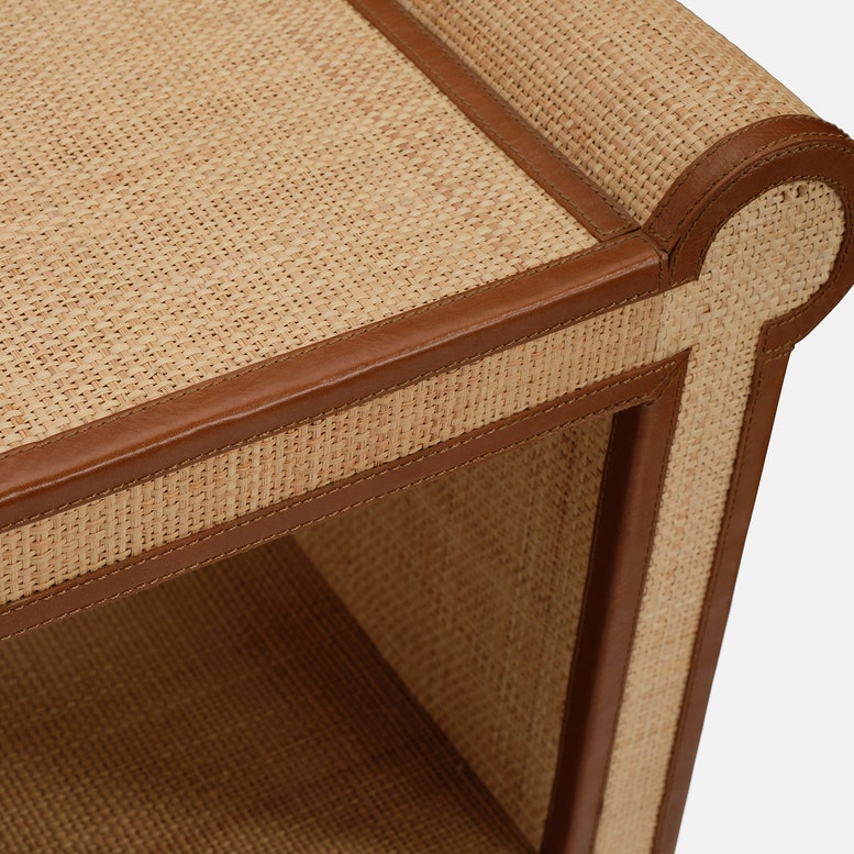 Close-up of the Large Matthew Console by Made Goods, highlighting its woven rattan and wood finish with full-grain leather trim on the corners, showcasing the console's distinctive design.