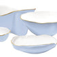From Beatriz Ball’s Encanto Periwinkle Serveware Collection, these four ceramic dishes showcase light blue and white enameled colors with irregular gold rims for an elegant touch.