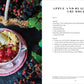 A bowl of apple and blackberry crumble with vanilla ice cream sits on a floral plate, providing perfect party inspiration from Common Ground’s “An Entertaining Story” by India Hicks; a basket of blackberries and recipe text are also visible.