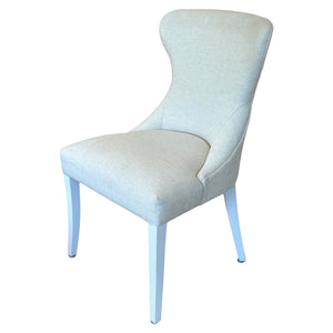The Curved Back Dining Chair by Lee Industries offers luxurious seating with a modern curved back, light fabric upholstery, and four straight white legs for sophisticated style.