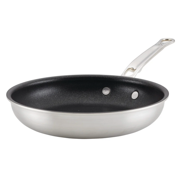 The Hestan Thomas Keller Commercial Clad Stainless Steel TITUM® Nonstick Sauté Pan, 12.5", features Italian craftsmanship with a titanium plasma-enhanced nonstick coating and a sturdy metal handle.