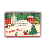 Rectangular metal tin of Vintage Christmas Village Gift Tags by Cavallini Papers and Co, featuring a vintage Christmas village scene with a decorated tree, people, and “36 Glittered Tags” text.