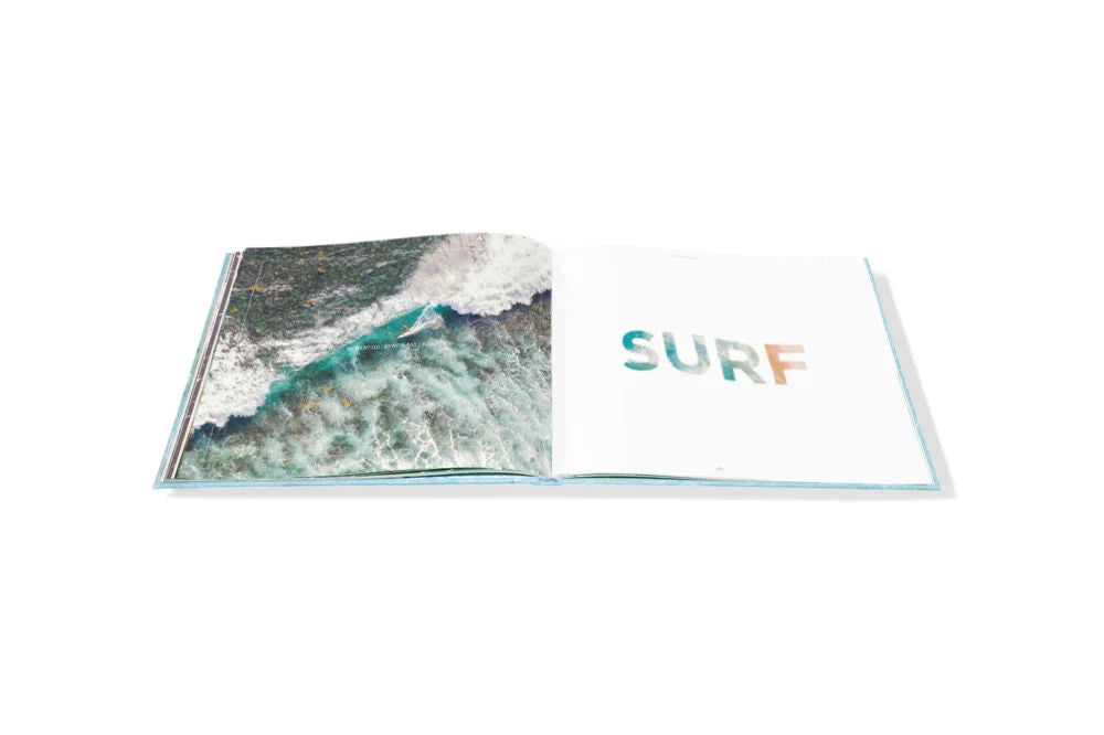 Open Escape travel photography book by Gray Malin displaying an aerial view of ocean waves on the left page and the word “SURF” on the right.