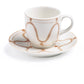 A white ceramic cup with a handle rests on a matching saucer, both from Themis Z's Serenity Beige Dinnerware Collection, featuring hand-painted brown wavy lines and circles.
