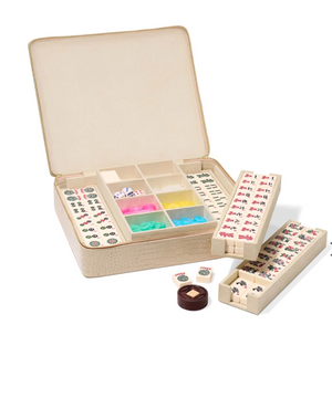 The Aerin Enzo Travel Mahjong Set in Fawn includes engraved tiles, dice, and betting chips, all organized in a chic open beige case.