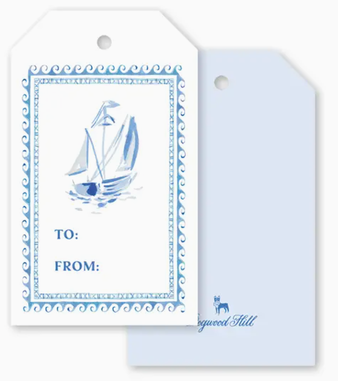 Two Dogwood-Hill Three Ships Sail Gift Tags: one featuring a blue watercolor sailboat illustration with “TO:” and “FROM:” lines, the other a plain light blue tag for gift wrapping.