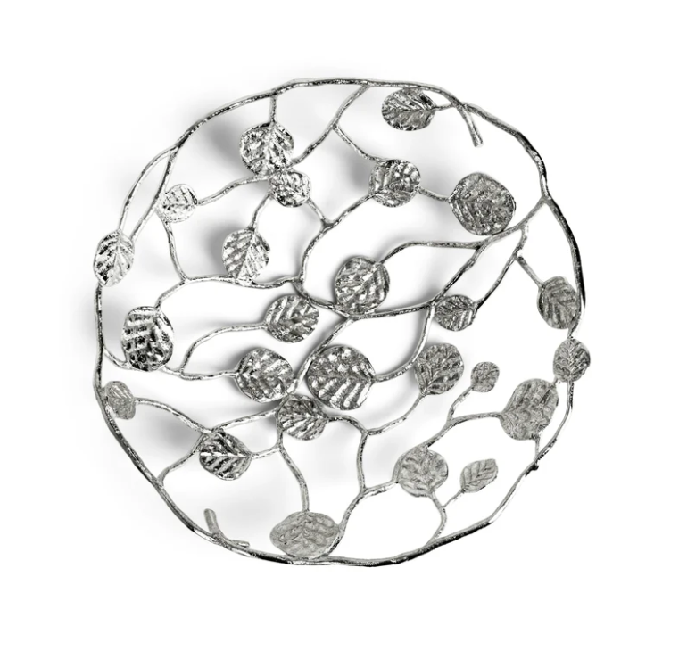 The Michael Aram Botanical Leaf Bread Basket is a round, silver decorative piece with an openwork branch, leaf, and foliage design from the Botanical Leaf Collection.