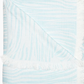 The Daasu Throw Collection by John Robshaw features a light blue and white stonewashed cotton towel with subtle wavy stripes, fringed edges, and a reversible design.