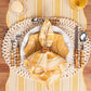 A place setting features the Juliska Cabana Stripe Tabletop Collection—a yellow and white placemat, white plate, yellow patterned napkin, bamboo cutlery, and a water glass atop a wooden table.