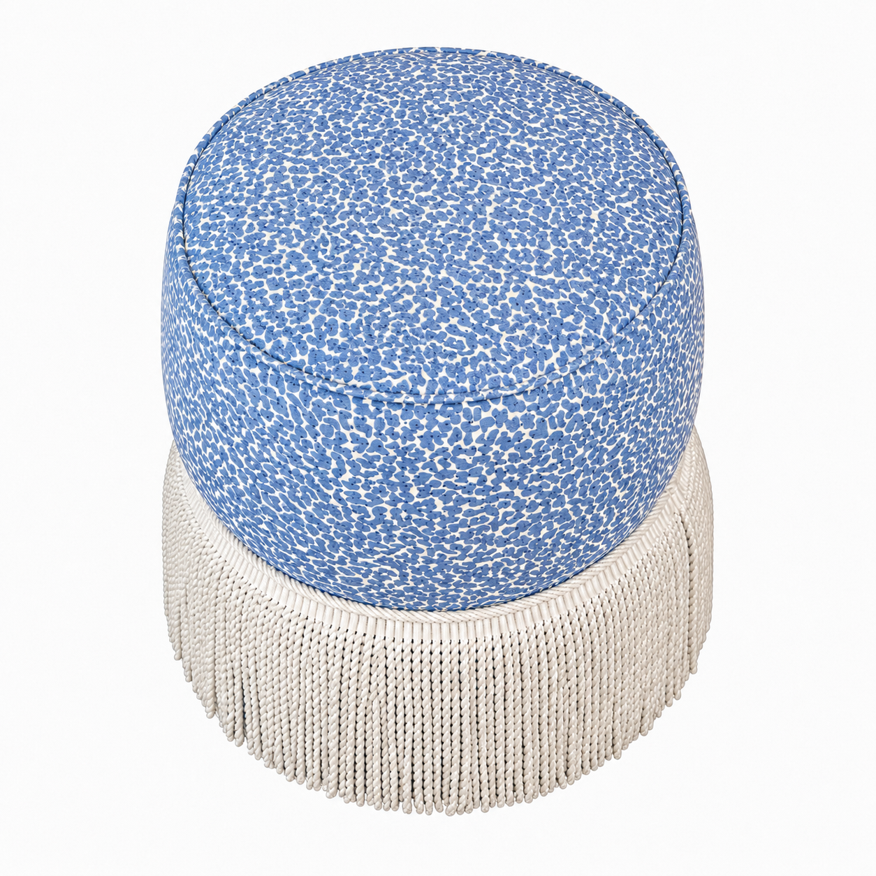 Experience the Amanda Stool by Hickory Chair—a round blue ottoman featuring a speckled pattern and white fringe trim around the base. Designed with double rounded tiers for extra style and comfort, this designer favorite is shown on a white background. Perfect for elevating any space, as seen at the Hive Trade Showroom.