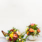 A floral cornucopia and a flower-filled white pumpkin vase sit on a pedestal table for a Hive Floral Class - Thanksgiving Class arrangement.