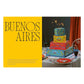 A Fancy Cakes tiered, square-shaped cake with intricate Baroque buttercream piping, decorated in blue, red, and yellow icing with sparklers, displayed on a table with party plates.