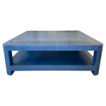 The Series O Custom Cocktail Table by T3 Custom Furniture is a square blue table with rounded edges, a lower shelf, and a textured azure finish inspired by Manila hemp.