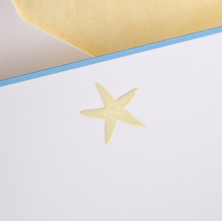 A cream card from the Printery Starfish Cream Note Card Set (box of 10) displays a yellow starfish in the center, partially overlapping a pale yellow envelope accented with a blue border.