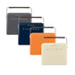 Four Fieldbar The Gin Trunk hard case coolers in dark grey, navy blue, orange, and cream are lined up. Each features a wooden handle, gold front lettering, and delivers superior thermal performance for your outings.